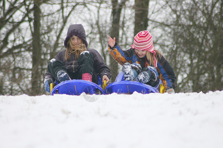 两个金发女孩在雪中玩得开心高清图片