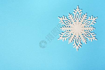 柔和的蓝色背景上闪闪发光的白色雪花背景图片