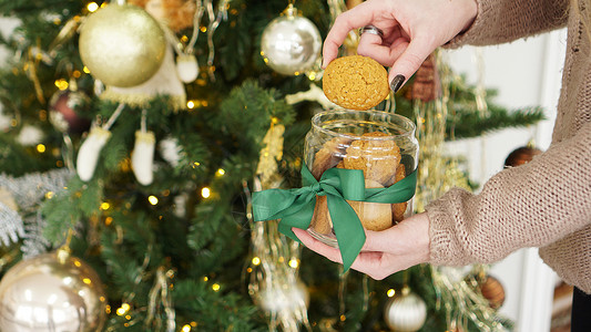 礼物罐子在一个玻璃罐子里的燕麦饼干 在圣诞装饰的背景之下 分支机构 展示背景