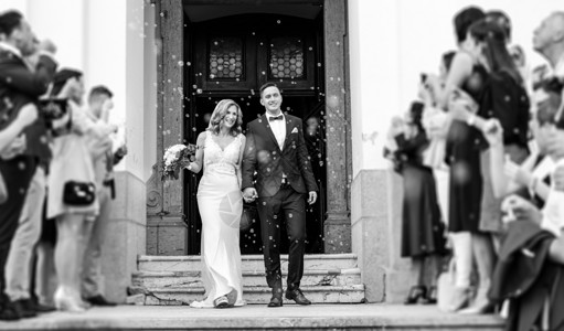 新婚夫妇在婚礼后离开教堂 家人和朋友用肥皂泡淋浴庆祝他们的爱情 破坏传统米浴的习俗 新娘 教堂婚礼背景图片