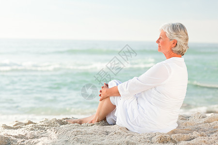 坐在沙滩上的女人 晴天 女性 高级的 海滩 退休背景图片