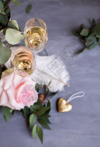 含有藤和花的玻璃杯 灰混凝土背景上的鲜花 羽毛 婚礼背景图片