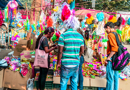 服装街城市街市场摊位上的人们在洒红节期间购买粉末干色和 pichkari 洒红节是庆祝整个印度次大陆的著名色彩节日 印度加尔各答 20背景