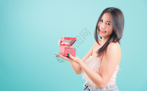 女人站着微笑 打开一个红礼物盒 生日惊喜背景图片
