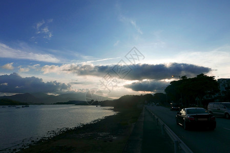 海洋 戏剧性的天空和路上的汽车 山 岛背景图片