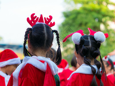 女孩穿着红主题服装 在圣诞晚会的初等学校 派对背景图片