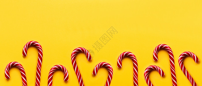 黄色背景的圣诞糖果锥壳 色彩多彩 锥体 假期背景图片