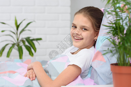 早上快乐的十岁女孩躺在床上 微笑在框中 笑声高清图片