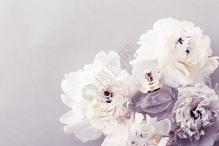 紫花香水瓶作为奢华香水产品 其背景是小马花 豆香广告和美容品牌 化妆品 柑橘背景图片