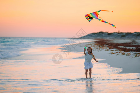 放风筝小姑娘小姑娘在海滩上放风筝 喝松松水 玩具 行动 加勒比背景