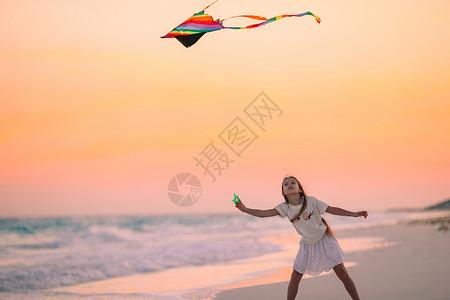 放风筝小姑娘小姑娘在海滩上放风筝 喝松松水 跑步 微笑 行动背景