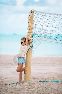 打排球的小女孩可爱的小女孩玩排球 在海滩上与球 活动 运动背景