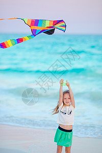 在热带海滩上放风筝的小奔跑女孩 孩子在海边玩耍 沙滩玩具的孩子图片