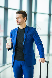 在机场里面喝咖啡的都市人 穿着西装夹克的休闲小男孩 在机场等待登机时拿着手机的白人男子背景图片