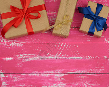 奶粉包装素材包着棕色奶粉纸和丝带 粉红木头的礼品背景