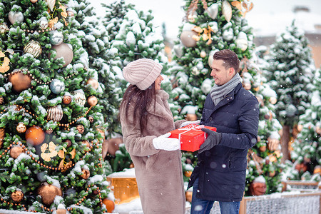 年轻快乐的情侣 在城市街道上庆祝圣诞节 并赠送礼物给对方 笑声 浪漫的 畅快背景图片