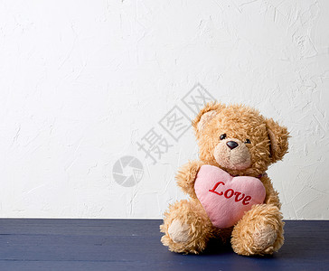 棕褐色可爱泰迪熊 握着粉红大心脏背景图片