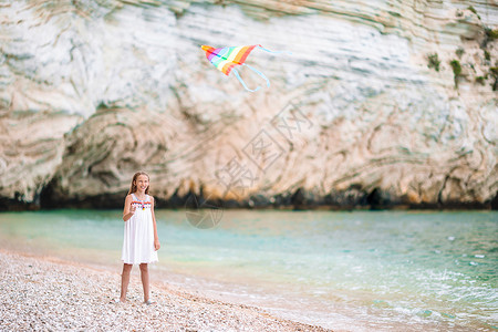 放风筝的小姑娘小姑娘在海滩上放风筝 喝松松水 快乐的 喜悦 跑步背景