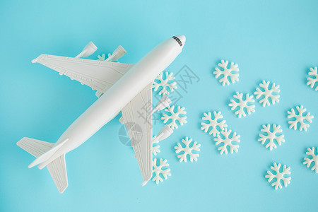 蓝天背景上的可塑玩具飞机和白雪花背景图片