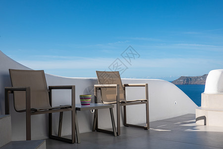 希腊圣托里尼岛的蓝色天空空桌和椅子背景图片