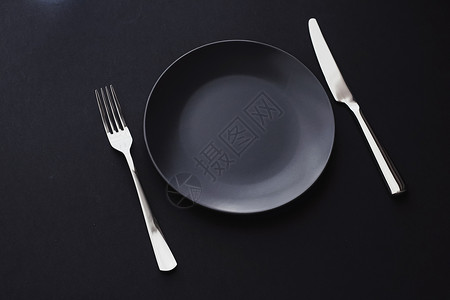 黑色背景的空板和银器 节日晚宴的优质餐桌餐具 最起码的设计和饮食 菜单 极简主义背景图片