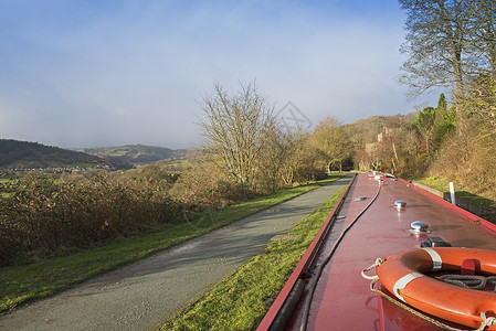 英国运河上的窄船在农村的一条小河上 夏天 树木高清图片