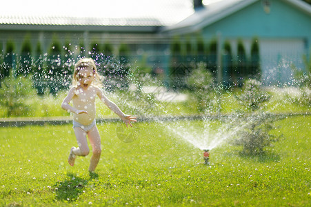 断流器房子女孩通过喷洒器跑来跑去 假期 冷却 草地 热的 生活背景