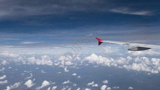 翅膀广告素材飞机旅行概念 从飞机窗口查看 飞机机翼下的云彩和蓝天 从宽角飞机的窗户看到 有旅行社背景的复制空间 乘客背景