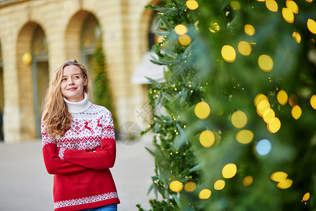 带着一棵明亮装饰的圣诞树的女孩 年轻的 冬天 城市背景图片