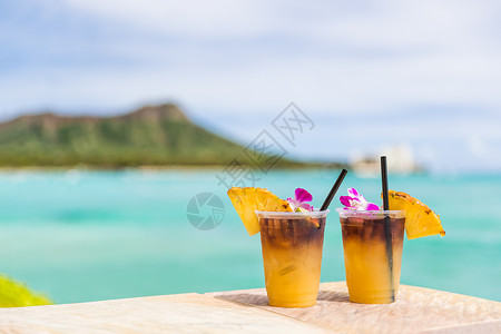 在夏威夷火奴鲁鲁的威基基海滩酒吧旅行度假时享用夏威夷麦泰饮品 夏威夷旅游胜地著名的夏威夷鸡尾酒 享有海洋和钻石头山的美景背景