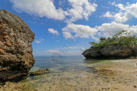 乌卢鲁巨石印度尼西亚巴厘岛巴东巴东海滩-自然度假背景 在印度洋上突出的巨石和岩层 天 云背景