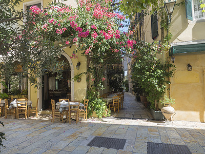 有腐必反科孚老镇Corfu旧城 有餐馆 咖啡桌和花园的可腐石街 夏季阳光明日 希腊爱奥尼亚群岛Kerkyra镇Corfu岛背景