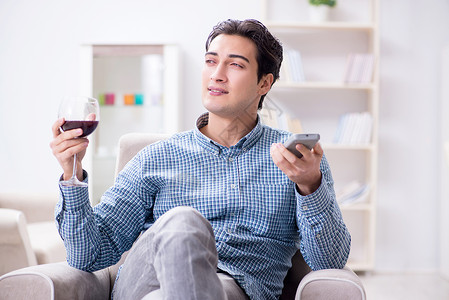 年轻男人在家喝葡萄酒 庆典 生日 干杯 享受 沙发背景图片