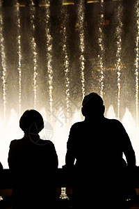 水景之王在拉斯维加斯欣赏贝拉吉奥喷泉奇观的人们剪影的夜景 旅游度假区 喷泉表演背景