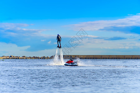 喷气滑水船漂浮在港口河边的阳光明媚的暑假里 滑翔在水上活动飞天板上 特技 娱乐背景