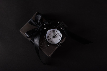 黑纸 黑色弓领带和黑色A包着的礼品盒 市场背景图片