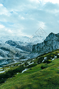 近距离接近山峰的山脉 用充满活力的青绿草地背景图片