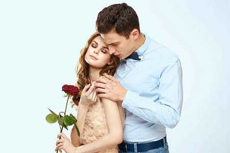 年轻情侣拥抱浪漫 约会生活方式 关系关系淡淡背景红玫瑰 家庭 周年纪念日背景图片