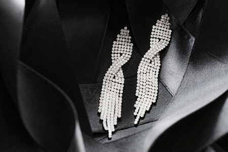 作为背景 珠宝和时装品牌的黑丝丝带上的豪华钻石耳环 奢华 丝绸图片