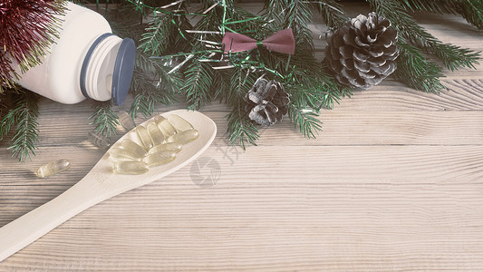 圣诞促销标签胶囊圣诞节药品 药丸和圣诞装饰品 天 药罐 木勺子背景