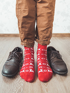 穿着斜纹棉布裤和亮红色驯鹿袜的年轻人准备穿 sude 鞋 斯堪的纳维亚模式 寒假精神 新年和圣诞节庆祝活动的休闲装背景图片
