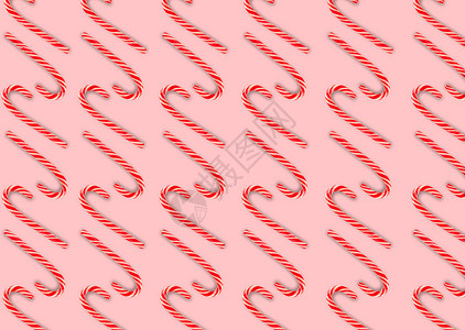 粉红色背景上有棒棒糖的平面构图 圣诞色彩的糖果手杖条纹图案 红白条纹棒棒糖 圣诞节背景 糖果店的概念背景图片