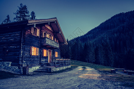 黄昏时期的假期 夜晚的铁石木农庄小屋 石头背景图片