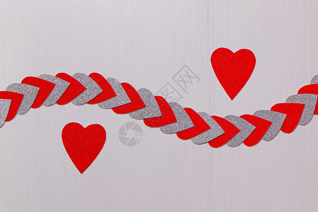 两颗红色的心与带纹理的白色心串分开背景图片