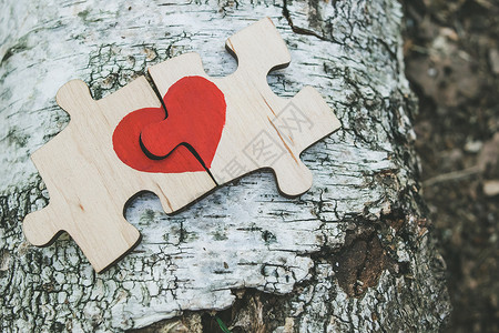 心拼图红色的心被画在木制背景上并排放置的木制拼图上 爱情观 圣瓦伦丁达 婚礼 解决方案背景