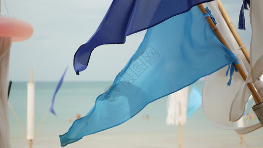 三角拉旗蓝色的旗帜在风中飘扬 热带海滩多云天气中 小三角蓝旗在风中飘扬背景