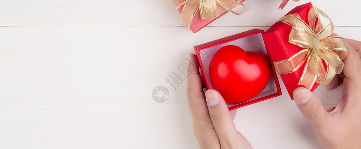 心形礼物盒子情人节 手开红色礼盒 心形木制白色背景 庆祝和周年纪念 给予爱 呈现浪漫和惊喜 节日和节日概念 问候语 假期背景