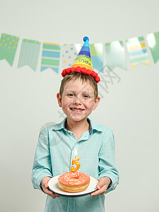 五岁生日生日甜甜甜圈与蜡烛在男孩手中 孩子 乐趣 盘子背景