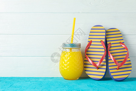 暑假招生传单在白木背景 文字空间的彩色桌子上配有新鲜果汁的翻转浮图和玻璃罐 暑假背景 太阳 橡皮背景