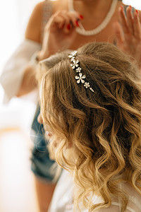 在婚礼筹备期间 发型师在新娘的发型上加了一个发型背景
